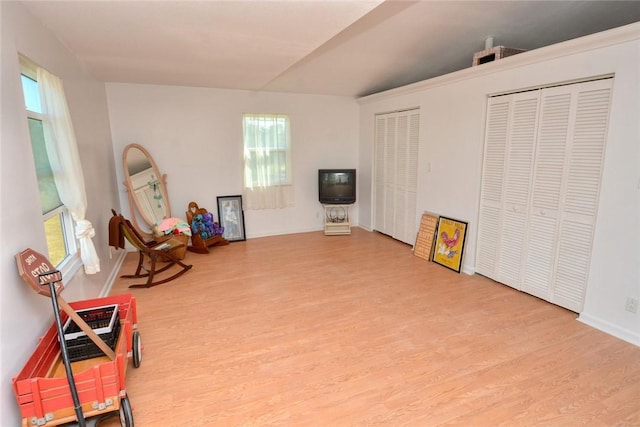 sitting room with hardwood / wood-style floors and lofted ceiling