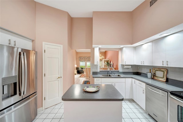 202 N Carmel Ct, Vero Beach, FL 32963 - kitchen featuring dark countertops, stainless steel appliances, a towering ceiling, and a sink