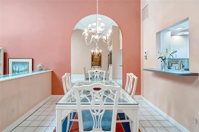 202 N Carmel Ct, Vero Beach, FL 32963 - dining room featuring tile patterned flooring, arched walkways, an inviting chandelier, and visible vents