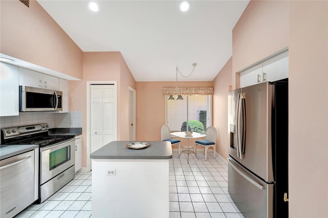 202 N Carmel Ct, Vero Beach, FL 32963 - kitchen with lofted ceiling, white cabinetry, decorative backsplash, appliances with stainless steel finishes, and light tile patterned flooring