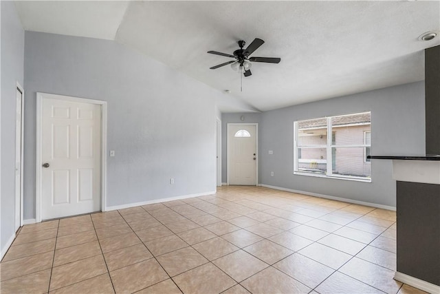4755 29th Ave, Vero Beach, FL 32967 - unfurnished living room with vaulted ceiling, a ceiling fan, light tile patterned floors, and baseboards