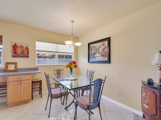 dining space featuring light tile patterned floors and a notable chandelier