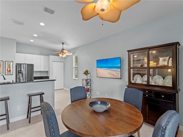 tiled dining area featuring vaulted ceiling and ceiling fan