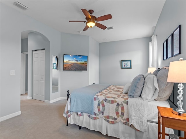 bedroom with ceiling fan, a closet, and light colored carpet