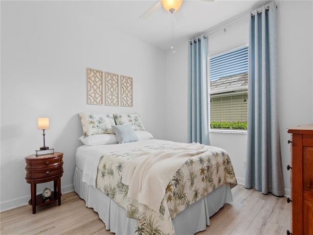 bedroom with light hardwood / wood-style floors, ceiling fan, and multiple windows