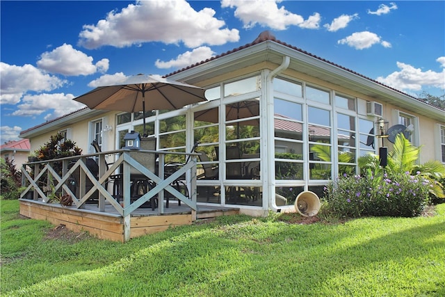 view of side of home with a lawn and a sunroom