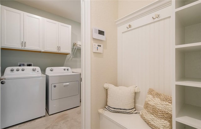 clothes washing area featuring cabinet space and washing machine and dryer