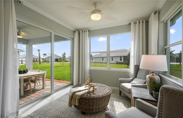 sunroom / solarium featuring crown molding, ceiling fan, and a residential view