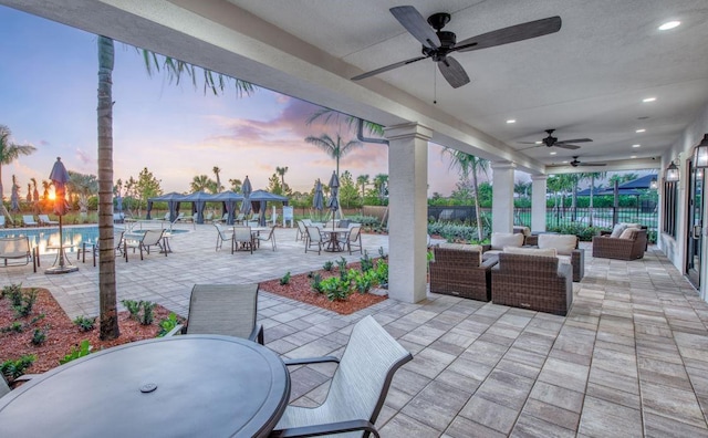 view of patio featuring fence, a gazebo, ceiling fan, outdoor dining area, and an outdoor living space