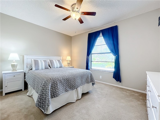 bedroom featuring light carpet, a textured ceiling, and ceiling fan