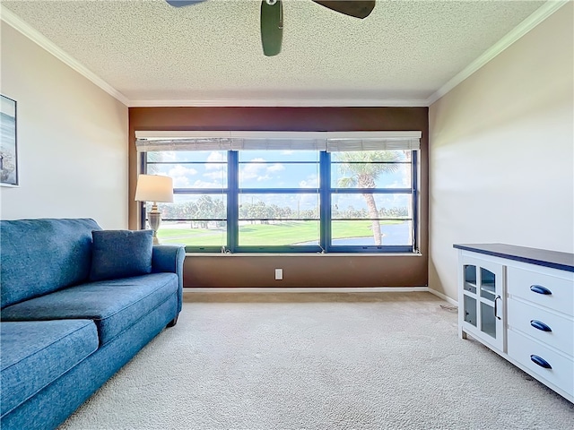 carpeted living room featuring plenty of natural light, ceiling fan, ornamental molding, and a textured ceiling