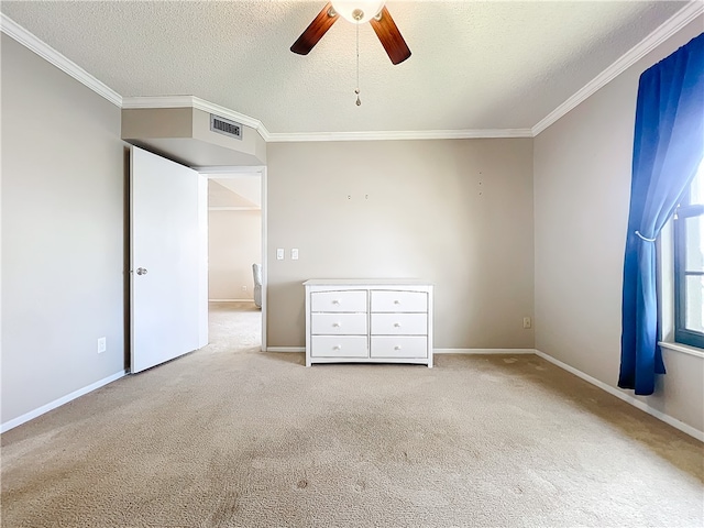 unfurnished bedroom with a textured ceiling, light colored carpet, ceiling fan, and crown molding