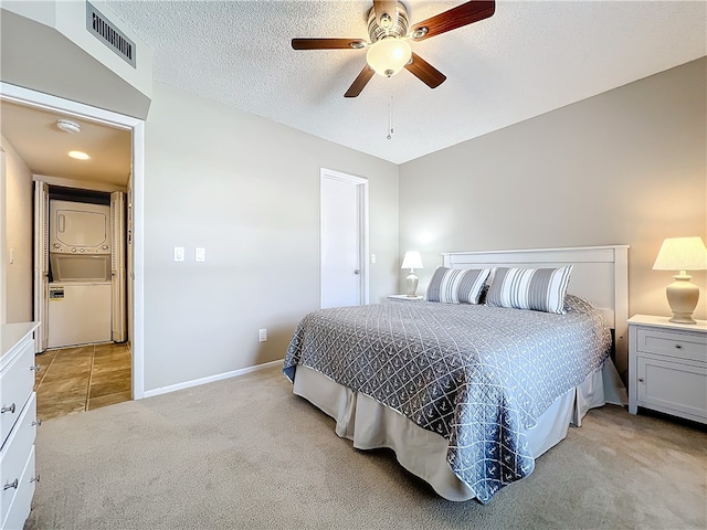 carpeted bedroom featuring ceiling fan and a textured ceiling