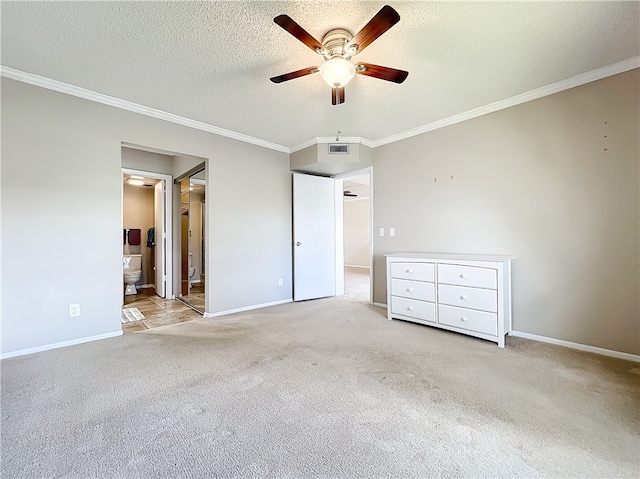 unfurnished bedroom featuring ensuite bathroom, ornamental molding, a textured ceiling, light colored carpet, and ceiling fan