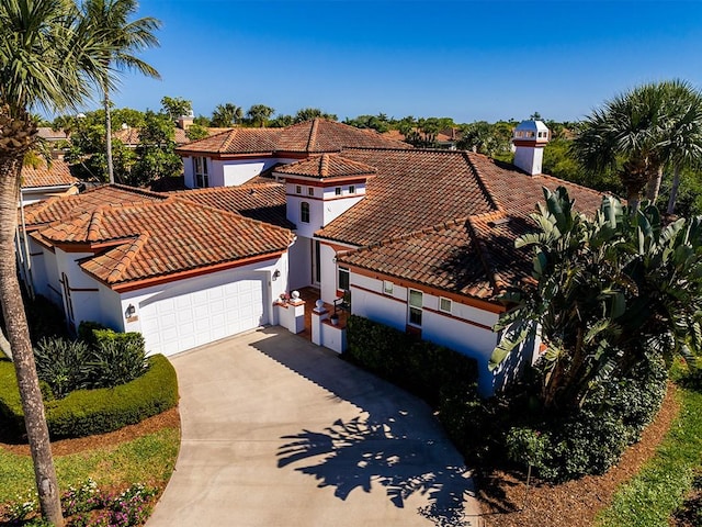 5235 W Harbor Village Dr, Vero Beach, FL 32967 - mediterranean / spanish-style home with stucco siding, a tiled roof, an attached garage, and driveway