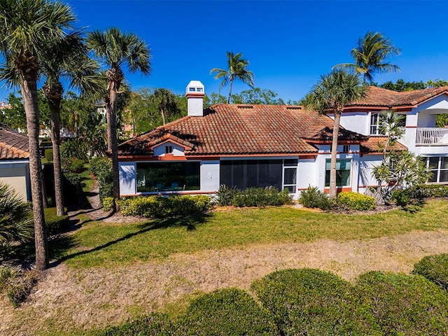 5235 W Harbor Village Dr, Vero Beach, FL 32967 - back of house featuring a lawn, a tile roof, and stucco siding