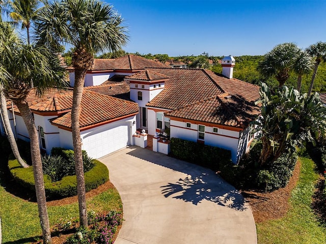 5235 W Harbor Village Dr, Vero Beach, FL 32967 - mediterranean / spanish home featuring stucco siding, a tiled roof, concrete driveway, and an attached garage