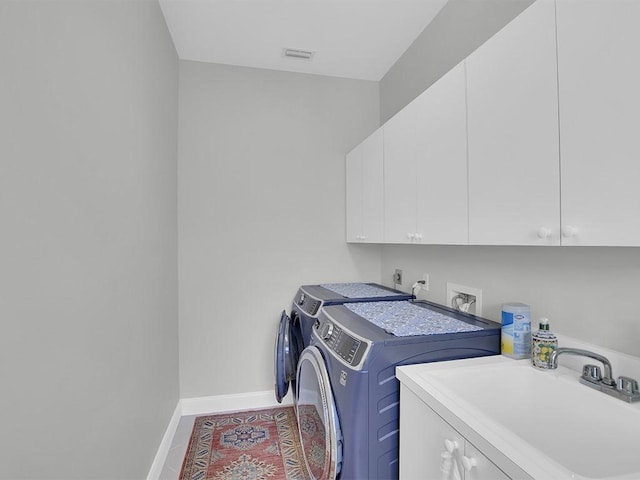 5235 W Harbor Village Dr, Vero Beach, FL 32967 - clothes washing area featuring visible vents, a sink, washing machine and dryer, cabinet space, and baseboards