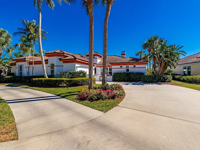 5235 W Harbor Village Dr, Vero Beach, FL 32967 - mediterranean / spanish-style home with a tile roof, driveway, and stucco siding