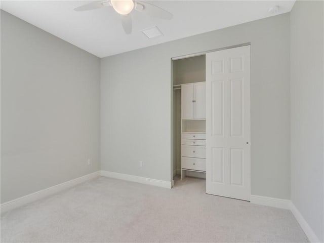 unfurnished bedroom featuring ceiling fan, light colored carpet, and a closet