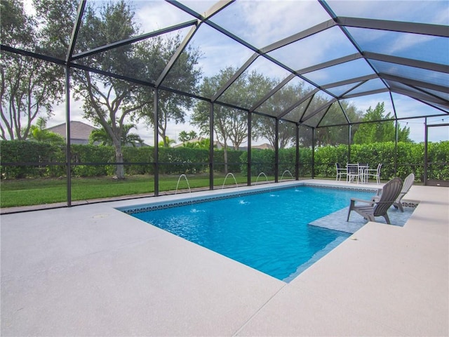 view of swimming pool with pool water feature, a patio, and a lanai