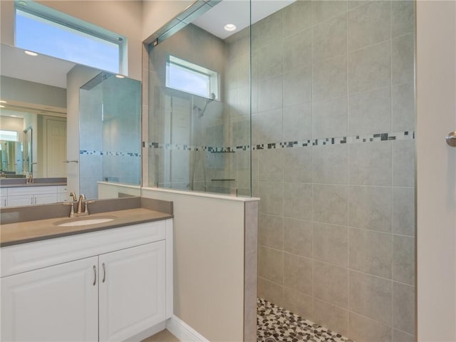 bathroom featuring tiled shower and vanity