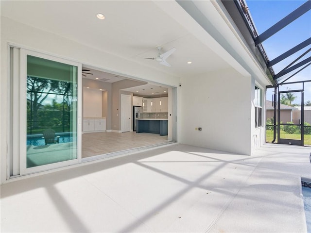 view of patio / terrace featuring ceiling fan and a lanai