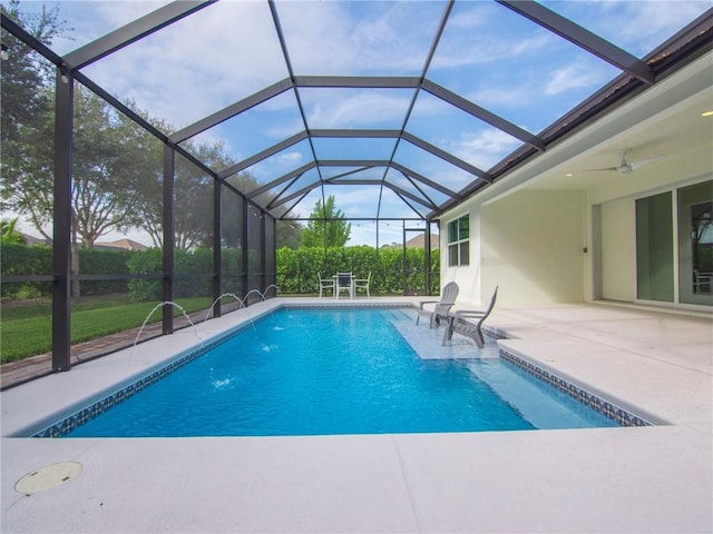 view of pool with ceiling fan, a lanai, and a patio