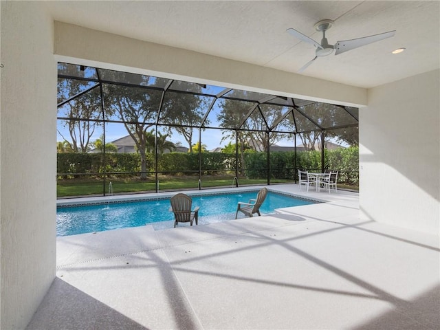 view of pool featuring ceiling fan, a patio, and glass enclosure