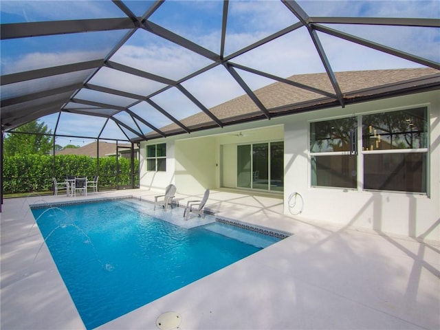 view of pool featuring pool water feature, glass enclosure, and a patio area