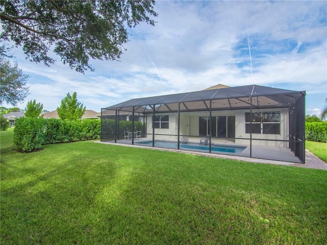 back of house with glass enclosure and a yard