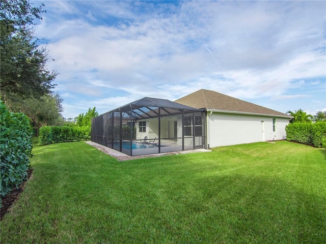 back of house featuring a lanai and a yard