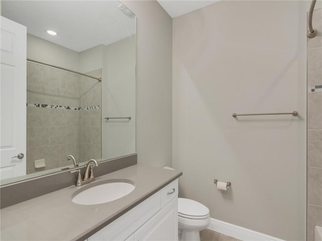 bathroom featuring a tile shower, vanity, and toilet