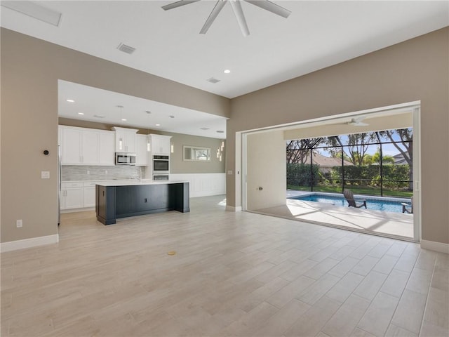 unfurnished living room with ceiling fan and light wood-type flooring