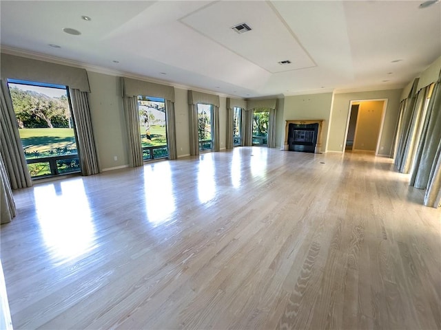 unfurnished living room featuring ornamental molding and light wood-type flooring