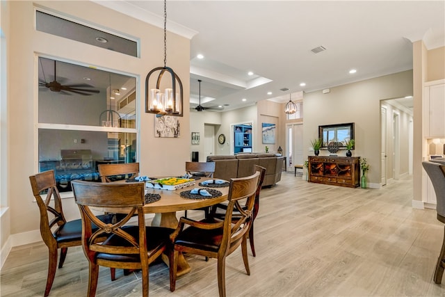 dining area featuring light hardwood / wood-style floors and ceiling fan with notable chandelier