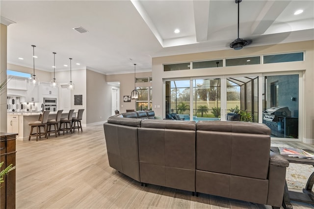 living room with ceiling fan, light wood-type flooring, and ornamental molding