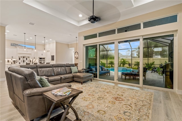 living room with light wood-type flooring, ceiling fan, and ornamental molding