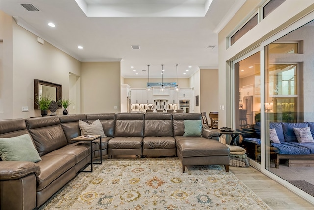 living room featuring crown molding and light hardwood / wood-style flooring