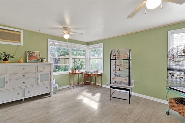 miscellaneous room with ceiling fan, an AC wall unit, and light wood-type flooring