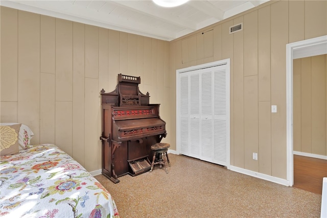 bedroom with beamed ceiling and a closet