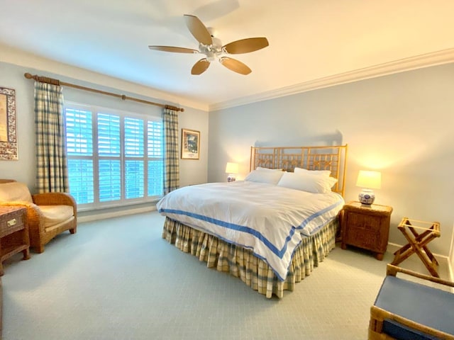 carpeted bedroom featuring ceiling fan and ornamental molding