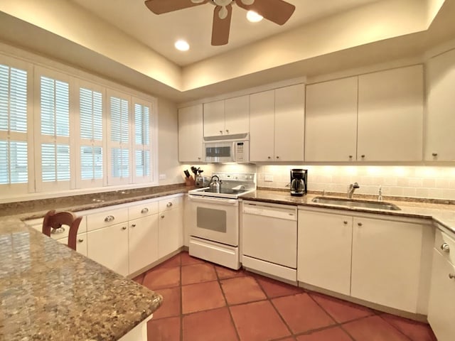 kitchen featuring white cabinets, tile patterned flooring, white appliances, and sink