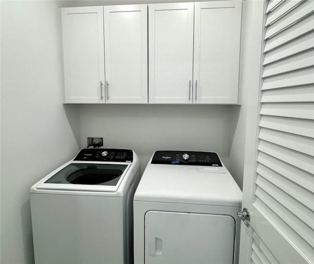 clothes washing area with cabinet space and independent washer and dryer