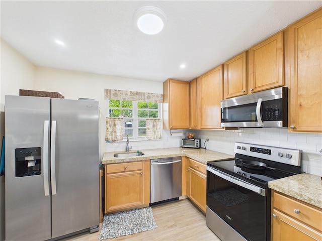 2297 Whiteside Ave SE, Palm Bay, FL 32909 - kitchen featuring light wood-style floors, light countertops, a sink, appliances with stainless steel finishes, and backsplash