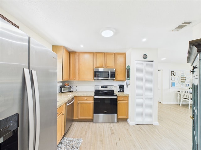 2297 Whiteside Ave SE, Palm Bay, FL 32909 - kitchen with visible vents, appliances with stainless steel finishes, a toaster, baseboards, and light wood finished floors