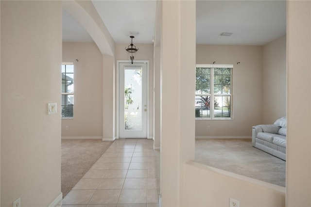 foyer entrance featuring plenty of natural light and light carpet