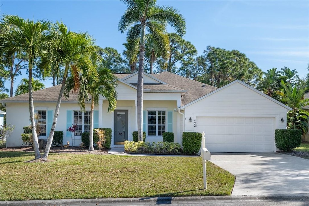 single story home with a garage and a front lawn