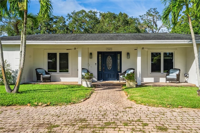 ranch-style house with a porch and a front lawn