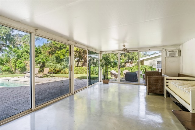 unfurnished sunroom with ceiling fan and a wall mounted air conditioner